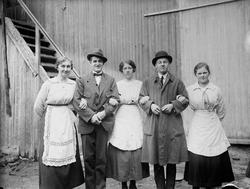 Gruppeportrett av fem personer: Tre kvinner i serveringsfork