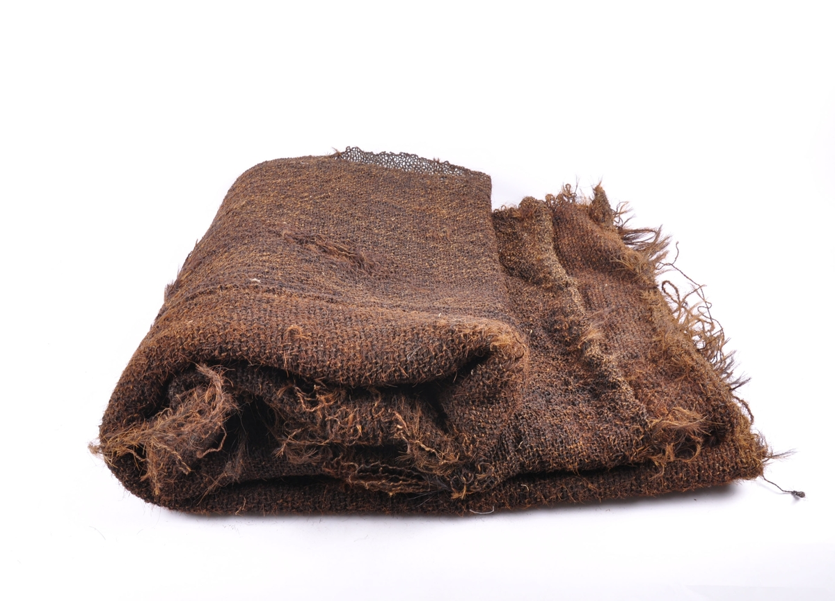 Grovt vevet teppe laget av grisebust, hestetagl og kuhalehår. 
Tre lange deler sydd sammen med langsgående søm.