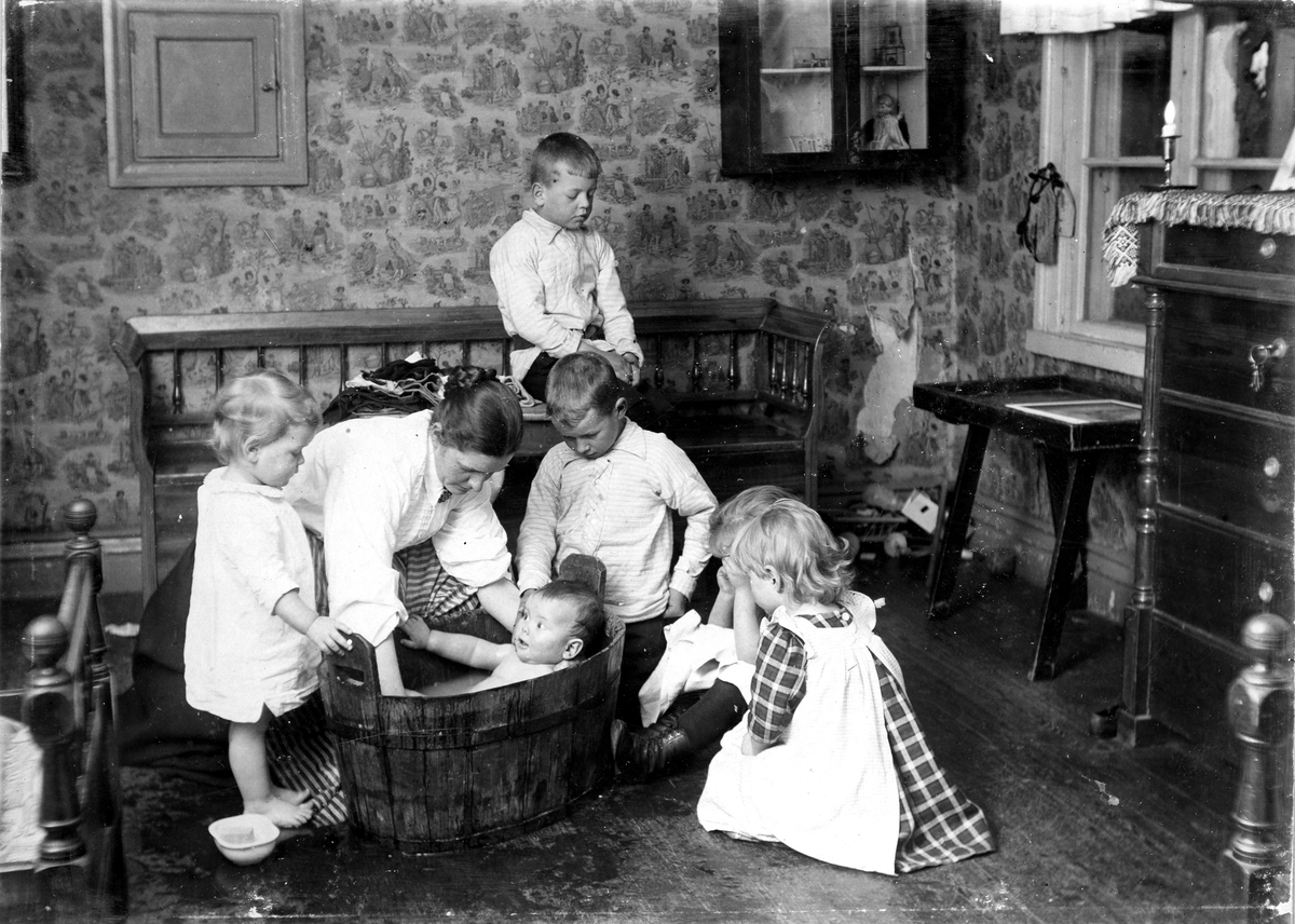 Från vänster Ivar Hallström, Nanny, Ivar (i balsam), Otto, (i soffan), Gunnar, Siri (skymd) och Liza. År 1902. Glasgatan ej villan. Fotograf Alfred Bergendahl. Givare H Bergendahl.