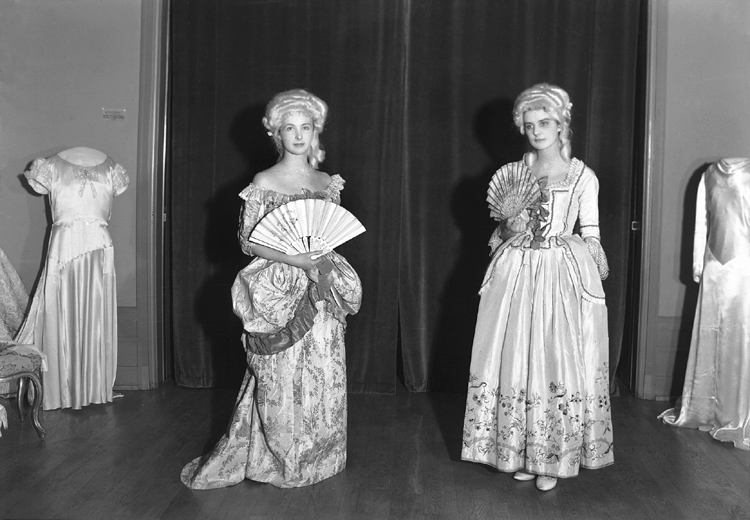 Två kvinnor i klänningar från 1700-talet.