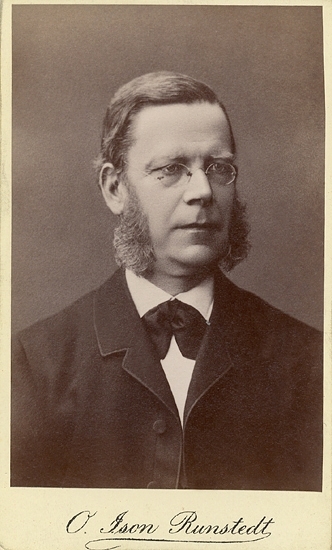 Porträtt (bröstbild, halvprofil) av en okänd, medelålders man med glasögon och stora polisonger (s.k. senatorspolisonger). Han är klädd i mörk kavaj  och vit skjorta med mörk fluga.