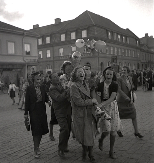 Studenterna, 1939. En kvinnlig student bärs iväg längs Stortorget av sina kompisar. I bakgrunden syns dåv. Skånska bankens hus m.m. i början av Storgatan.