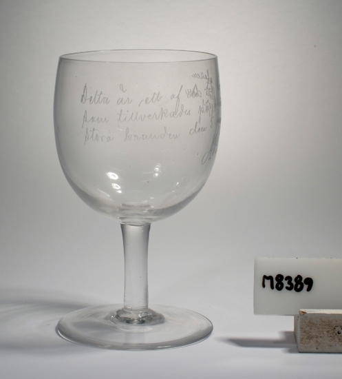 Glas (på ben och fot).
Beskrivning: Glaset har en inskription som lyder: "Detta är ett af de tre första glasen som tillverkades på Kosta efter den stora branden den 5 Augusti 1901. A.B."
Inskrivet i huvudkatalogen 1935.
Funktion: Glas