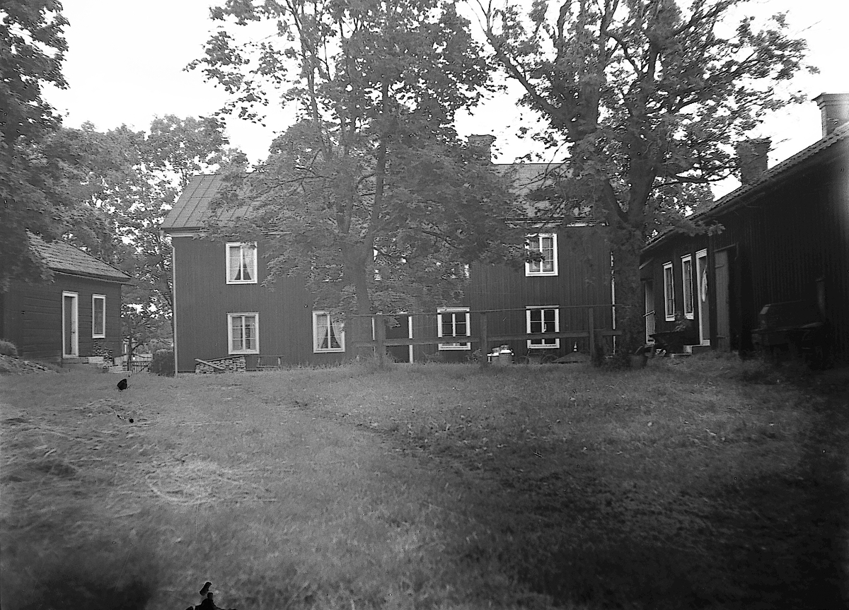 Bilden är tagen den 13 juli 1939 och föreställer gården Jon-Jons i Trödje. Den mycket stora mangårdsbyggnaden byggdes efter en förödande brand som drabbade flera gårdar i byn den 8 oktober 1854. När bilden togs ägdes gården av systrarna Stina och Karin Jonsson. Reportage för Norrlandsposten.