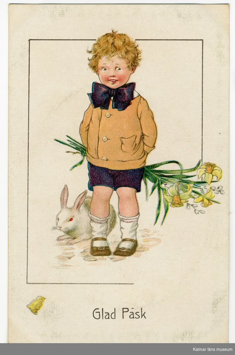 En pojke med lila rosett om halsen, ljusbrun jacka och lila shorts står och håller en bukett påskliljor och videkvistar bakom ryggen. Bakom honom till vänster ligger en vit kanin.
