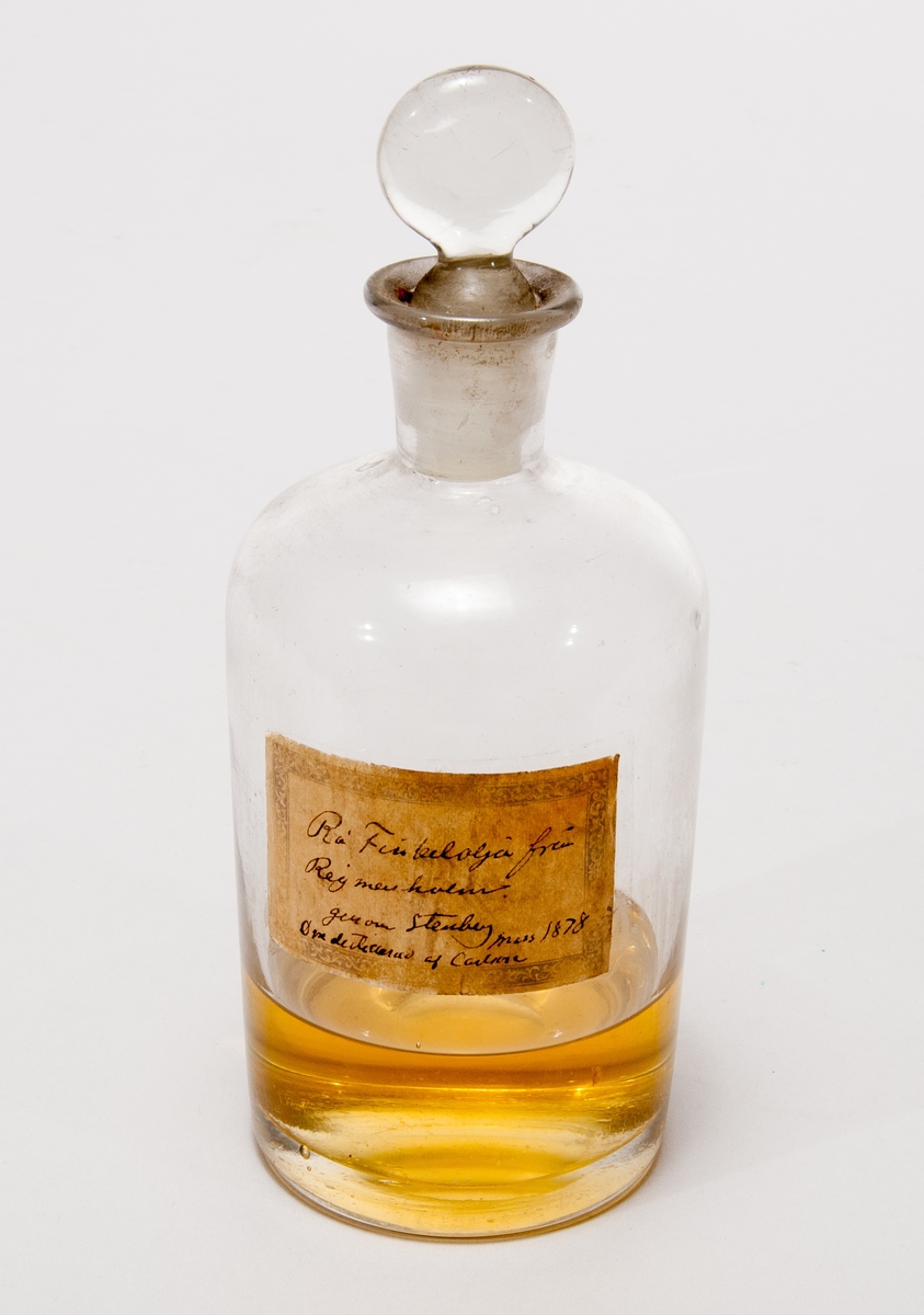 Prov på finkelolja. I flaska av glas med etikett: "Rå Finkelolja från Reijmersholm genom Stenberg mars 1878. Omdestillerad af Carlson."