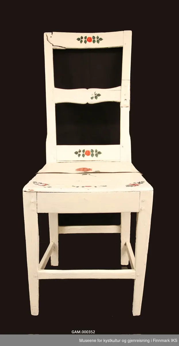 Stolen er malt hvit med blomster dekorasjon på.
