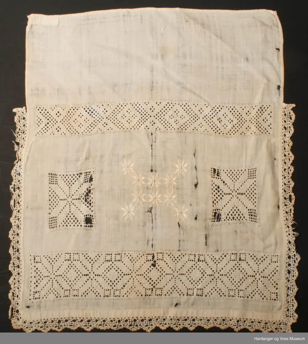 Over framstykket hekla blonde påsydd langs kanten, åttebladspirer