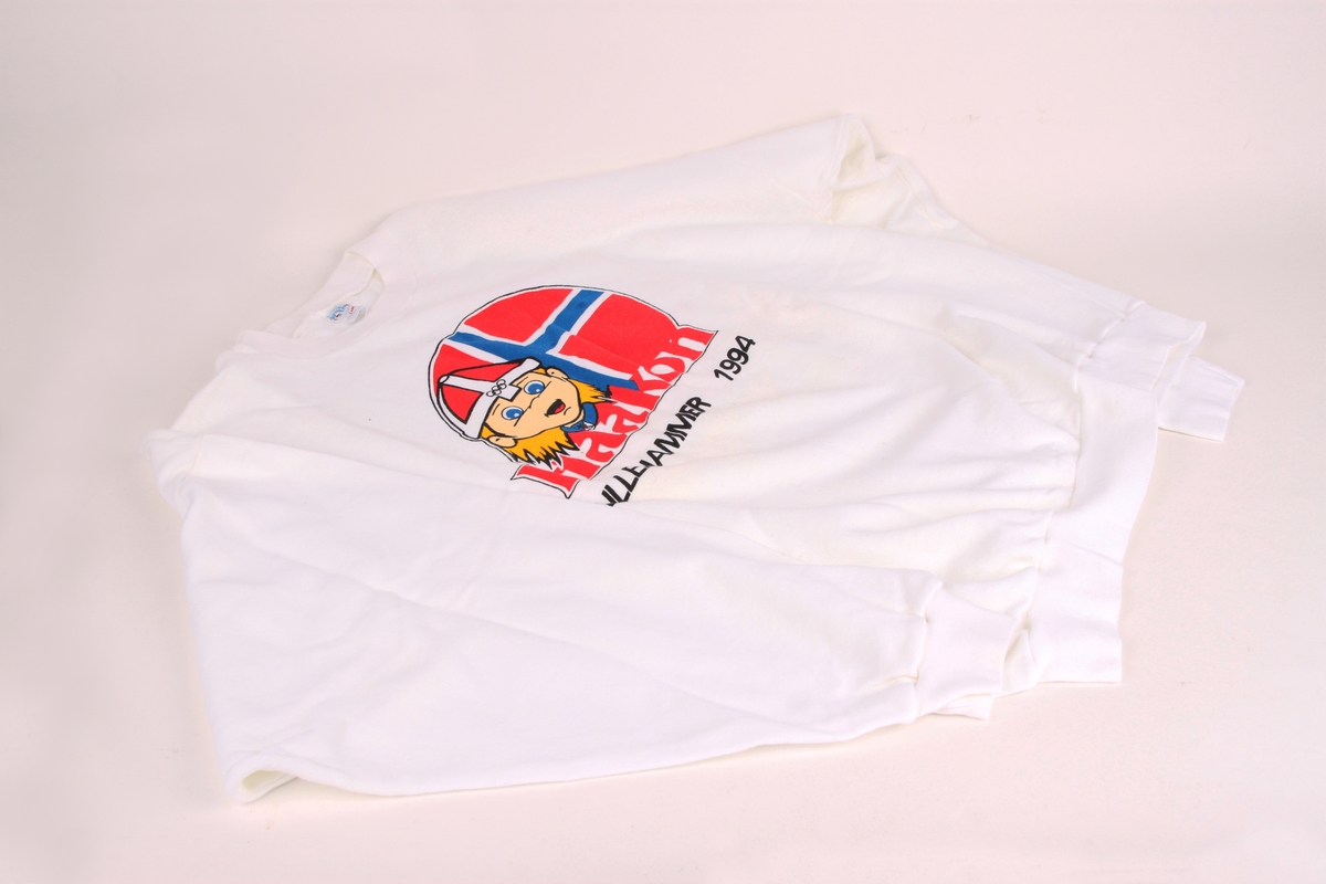 En genser i enkel fasong med rette ermer og rett i sidene. Genseren har OL-maskoten Haakon fra OL i Lillehammer 1994 som motiv foran på brystet.