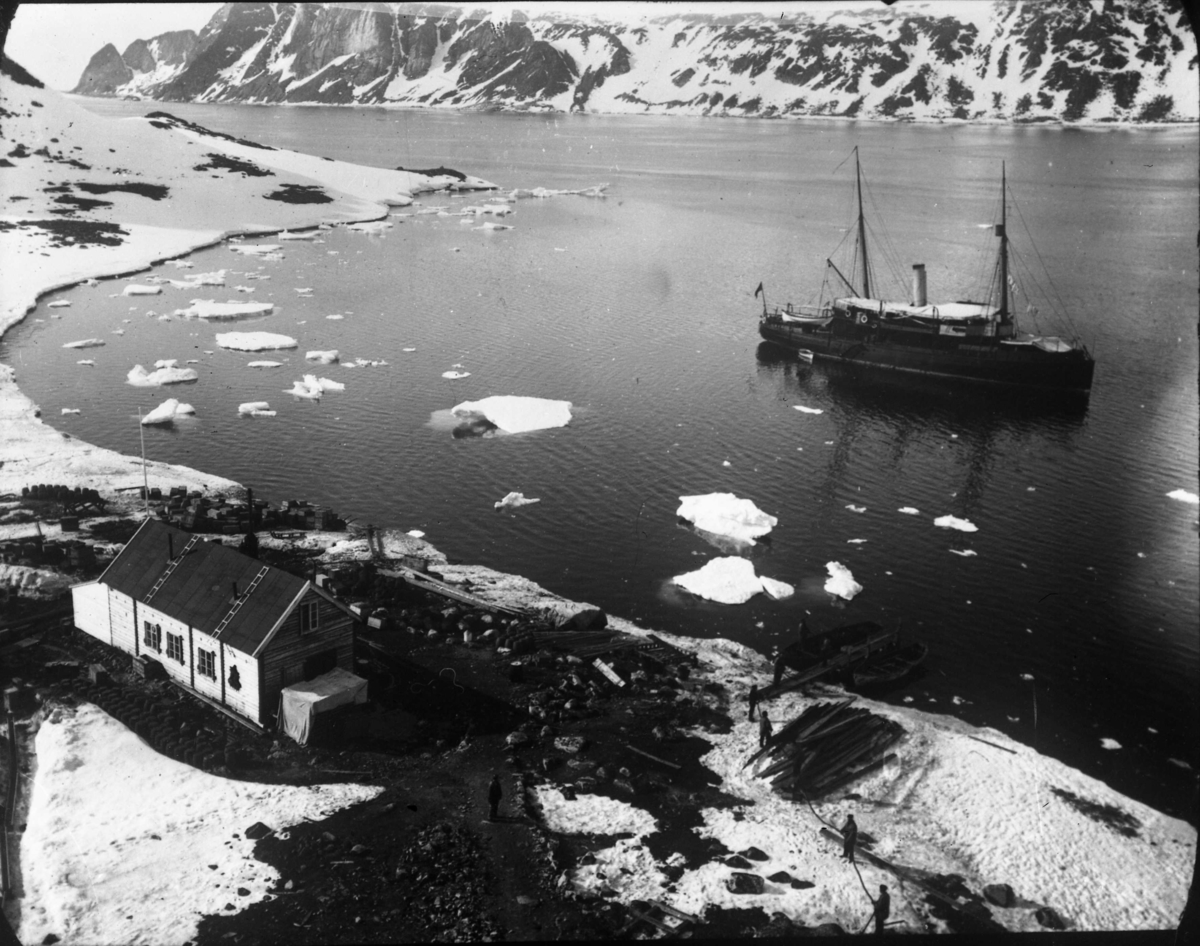 Vy från ballonghusets topp: Pikes hus och HMS Svensksund. Manskapet för iland släplinor. Glasplåt.