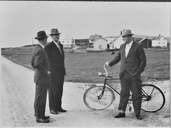 Menn med en sykkel på veien slår av en prat.