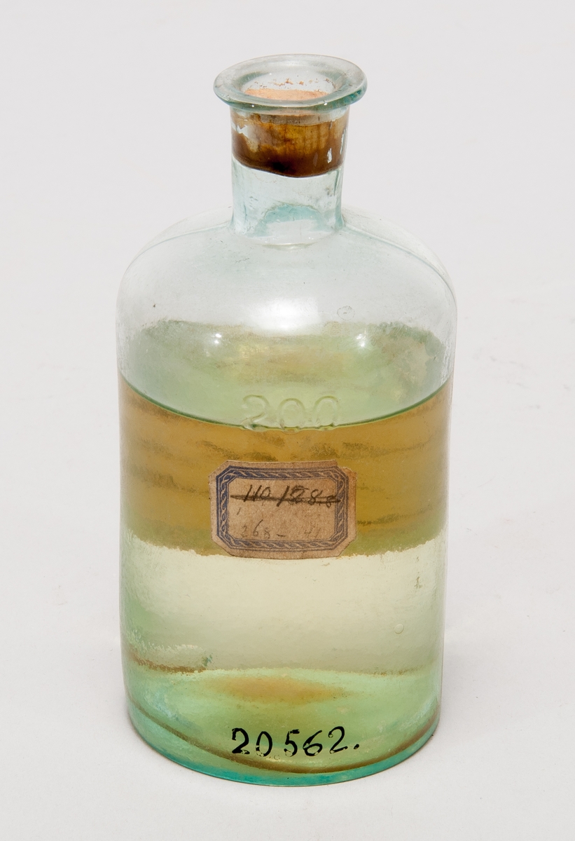 Prov på produkt ur finkelolja, i  flaska av glas med etikett: "No 10. Produkt ur finkelolja fr Reymersholm erh gen prof. Stenberg Kokp 107,1-128,[…] Mellanprodukt"