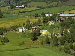 Kulturlandskap. Småhusbebyggelse, gårdsbruk bak i bildet.