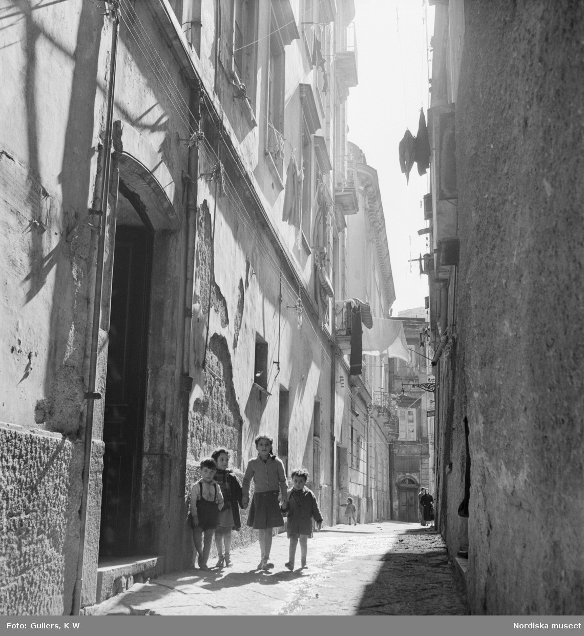 Fyra barn som kommer gående på en smal gata