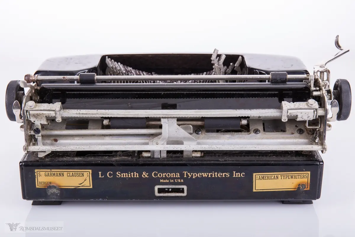 Mekanisk skrivemaskin med 49 tangenter. Plastkarosseri med avrundede kanter. Maskinen har en kvadratisk oppbevaringskasse med låsemekanisme og bærehåndtak i lær.
