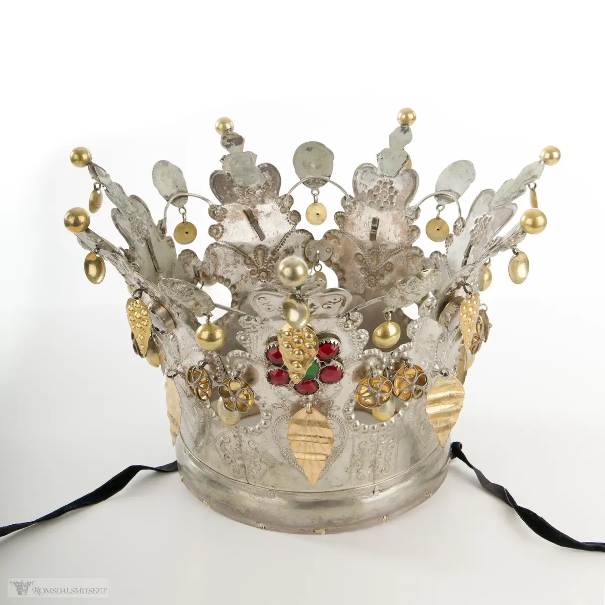 På bøylen mellom delene er loddet på et hode. Hjerte med blomst og blad på hver del.