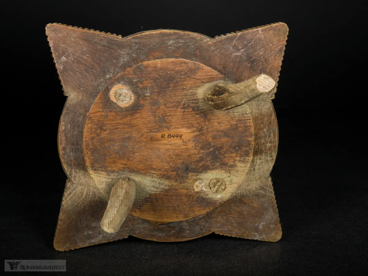 Utskjæring på fatet, små spisser i sirkler og på vinger. Ringene som omkranser midten minner om tannhjul.