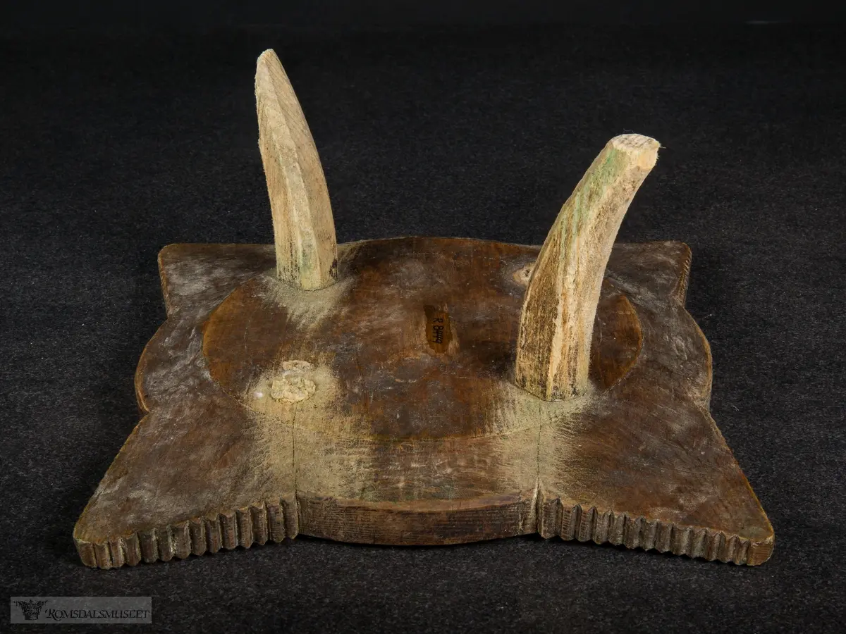 Utskjæring på fatet, små spisser i sirkler og på vinger. Ringene som omkranser midten minner om tannhjul.