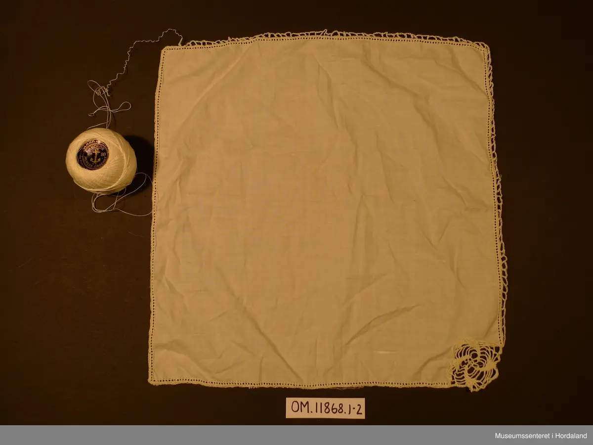 Uferdig arbeid, 2 lommedukar har hekla kant, i den eine er det og felt inn eit heklamotiv i eine hjørna, 4 tøystykke er berre klipte til, 4 motiv er ferdig hekla, klare til innfelling. I tillegg er det med 1 nøste hekleganr.
heklamotiva er firkanta, ca.3,5 x 3,5 cm