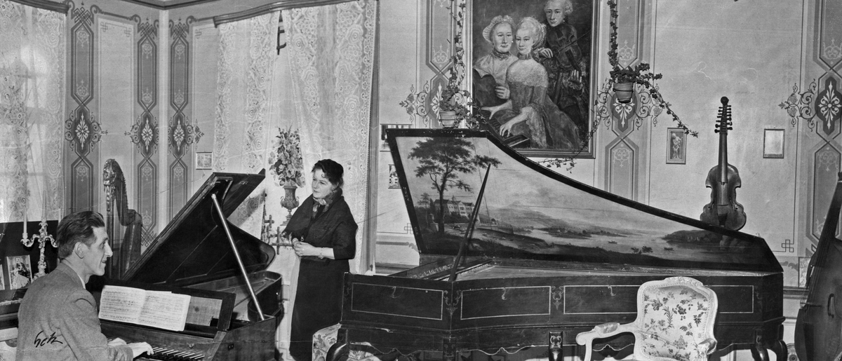 Kapellmester Finn Audum Oftedal spiller på André Stein pianoforte. Victoria Bachke står mellom det og en cembalo fra 1750. På veggene til høyre henger det en Viola dámore og en viola da gamba.