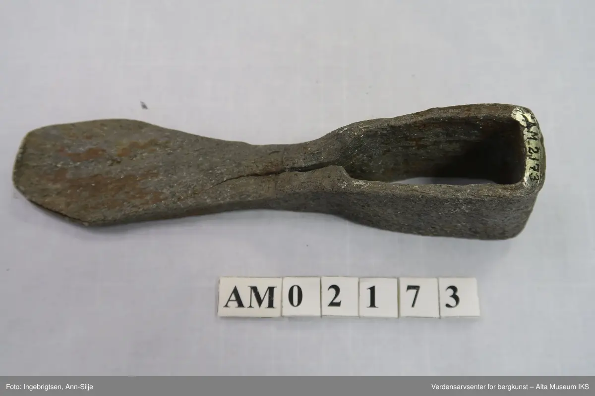 Hjemmesmidd jernhakke med innleggsstål. Jernet er brettet rundt skaftåpningen, det er lagt herdbart stål mellom. Hakken er hamret sammen (sveiset) på ambolt. I spissen er hakken stuket og sveiseskjøten er åpen både i spissen og fra skaftåpningen mot spissen. Dette tyder på mindre vellykket sveising, herding eller begge deler.