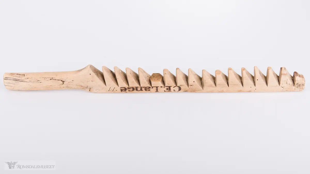 Avlang med håndtak og 16 tenner.