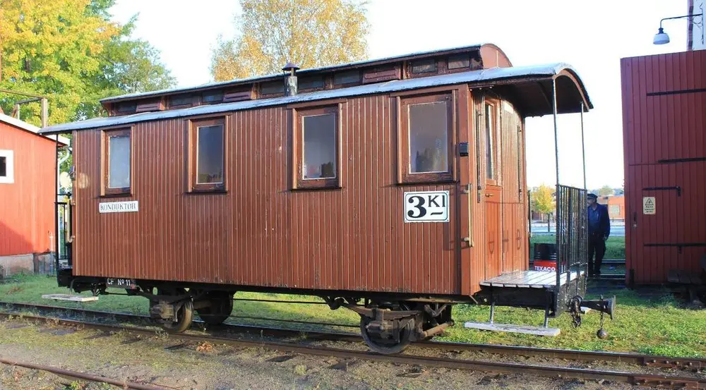 CF11 - vogn med en avdeling for konduktøren, og en avdeling for tredje klasse. Kledt utvendig med stående teak-panel.