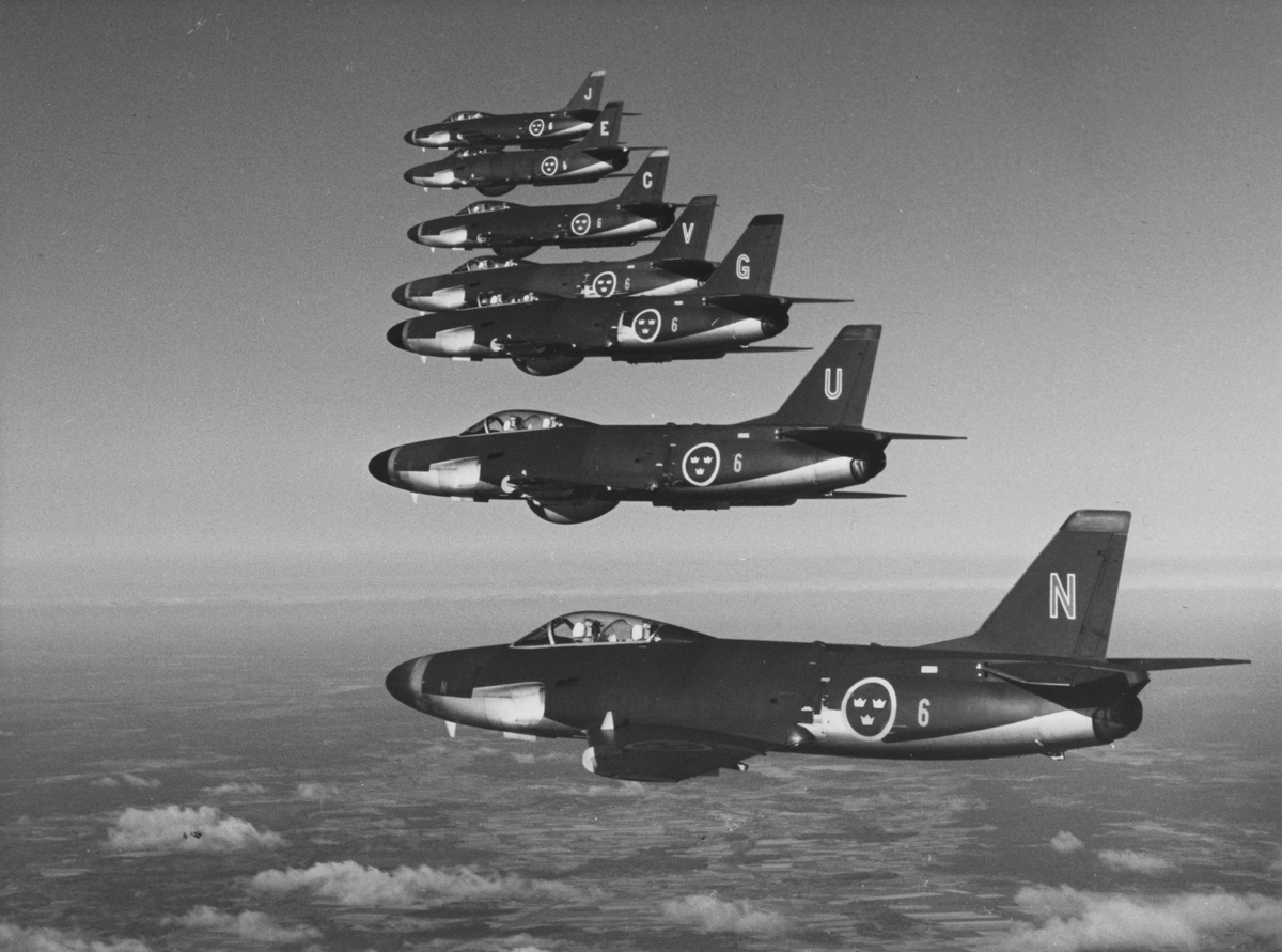Flygbild av sju stycken flygplan A 32 Lansen från F 6 Västgöta flygflottilj i luften.