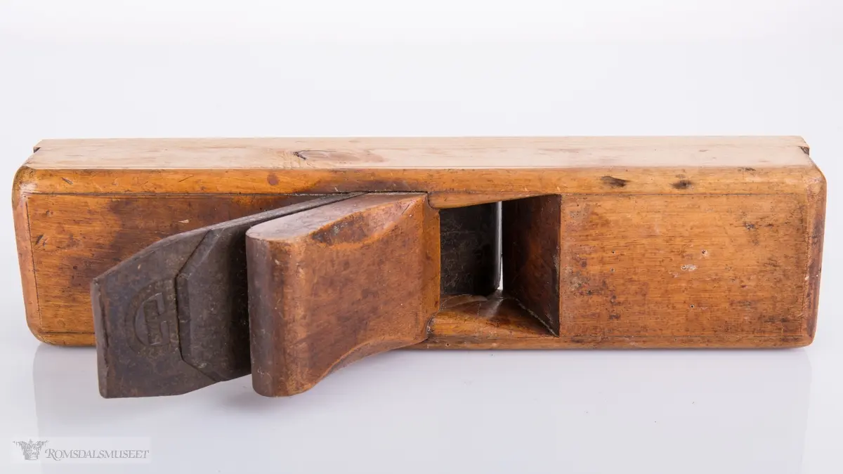 Rektangulær høvel med jern og kile. Har et spor på siden av sålen.