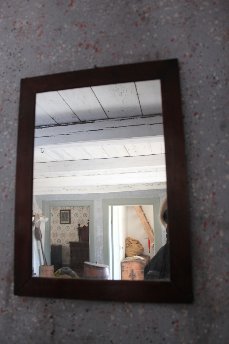 Spegel med 35 mm bred, slät ram av trä med vinkelsågade hörn. Betsad i rödbrun nyans.