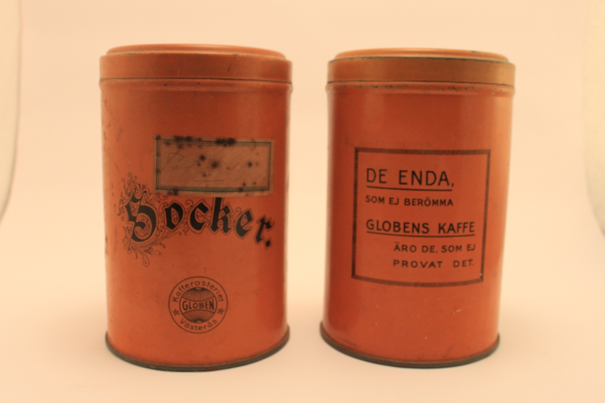 Cylindrisk orange plåtburk med lock och svart text "Socker"