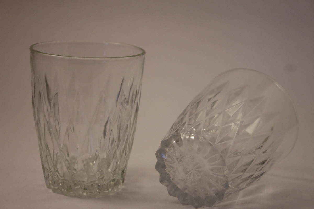 Tåvå dricksglas i pressat glas med mönster av inpressade romber.