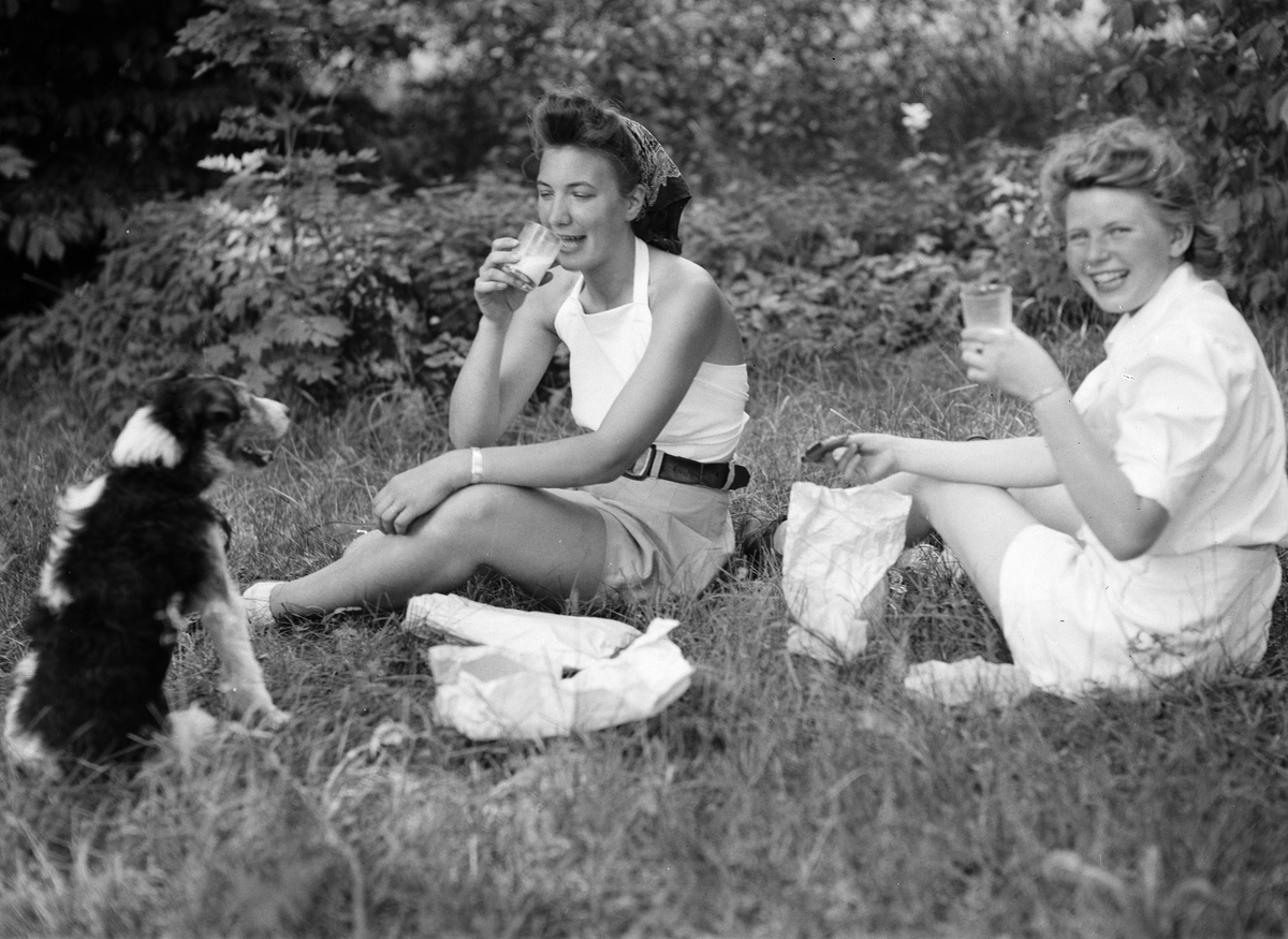 Unga kvinnor tar arbetsrast vid lövtäkt på Länna gård, Almunge. Samhällsinsats arrangerad av Länsarbetsnämnden i Uppsala län