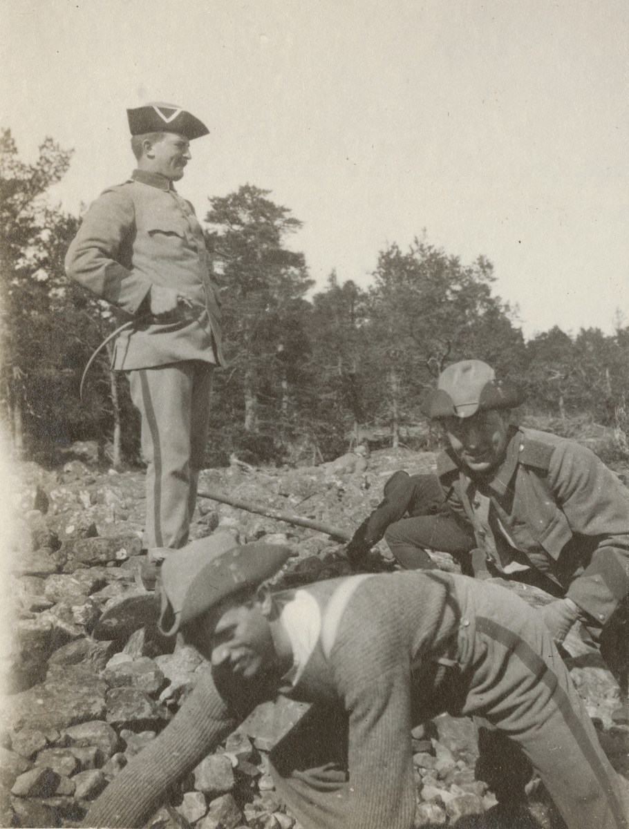 Officerare vid Göta livgarde bevakar soldater som arbetar med att förflytta stenar.