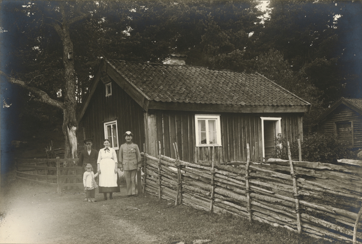 Soldaten Karl Magnus Berglund med hustru Hulda Emilia Sundell och barn utanför soldattorpet i Bunnström, Gränna, boställe under Jönköpings indelta infanteriregemente I 12.