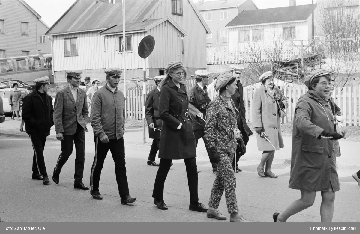 Vadsø 17.5.1969. Fotoserie av Vadsø-fotografen Ole Zahl-Mölö. Russen passerer i russetoget. Legg merke til den moteriktige 
damen med fargerik bukse og jakke - og polaroidkamera rundt halsen!