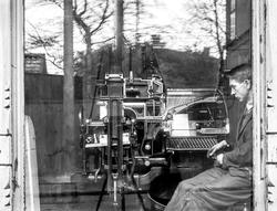 Avisa Sarpens trykkeri i Sarpsborg, mann passer trykkerimask