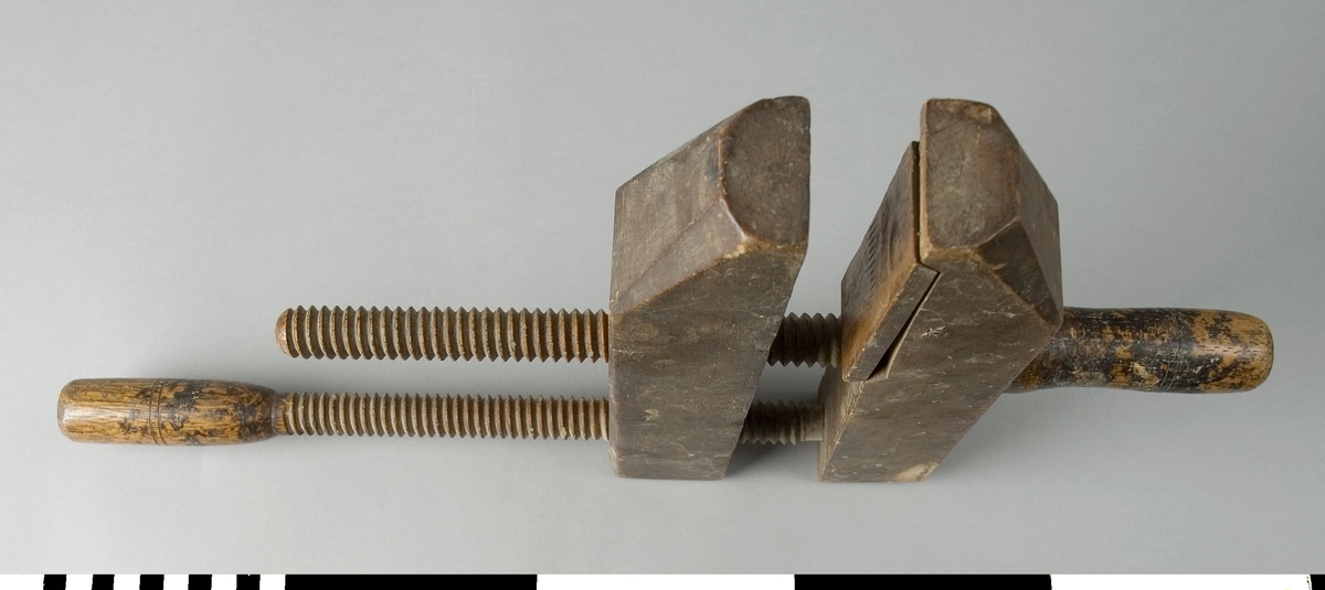 Skruvblock av trä. Skruvblocket består av två raka parallella trästycken som är förbundna med två träspindlar. Den ena träspindeln skruvas genom mitten av de båda trästyckena. Den andra skruvas genom ett av trästyckerna från det motsatta hållet cirka 25 mm från bakkanten av trästycket. Änden av spindeln kan skruvas in i ett ca. 20 mm djupt hål i det motstående trästycket. Det ena trästyckets del som ligger an med tryck mot arbetsstycket vid limning har en träplatta som är nedsänkt i trästycket med möjlighet att ändra vinkeln något vid pressining.

Funktion: Hålla ihop delar som limmas