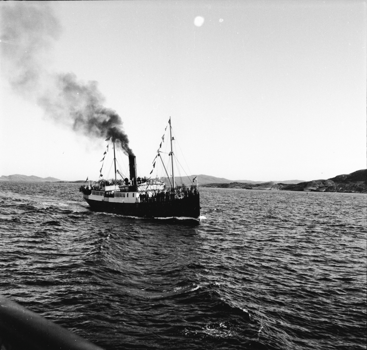 Flaggkledd dampbåt på veg til Vestlandske sangerstevne i Stavanger.