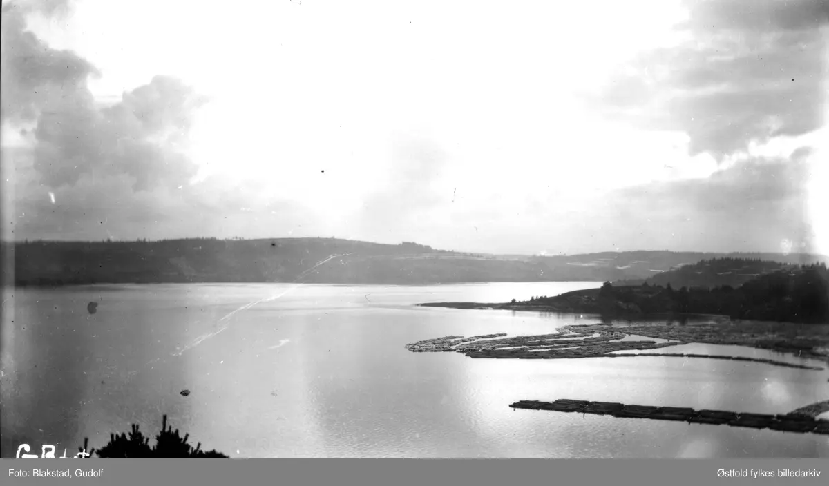 Tømmertunnelen i Eidet i Tune.
"Den ytterste delen på lensen ble kalt "leggen" (lengst ned til høyre). Midt på bildet synes ikke en såkalt "flyndre". På denne sto det også en "nokke", - den ble drevet manuelt, to mann dro tømmeret ut av lensa."
(Hjalmar Eriksen f. 1910, fortalt i 1993 til Ernst Gerhardt)