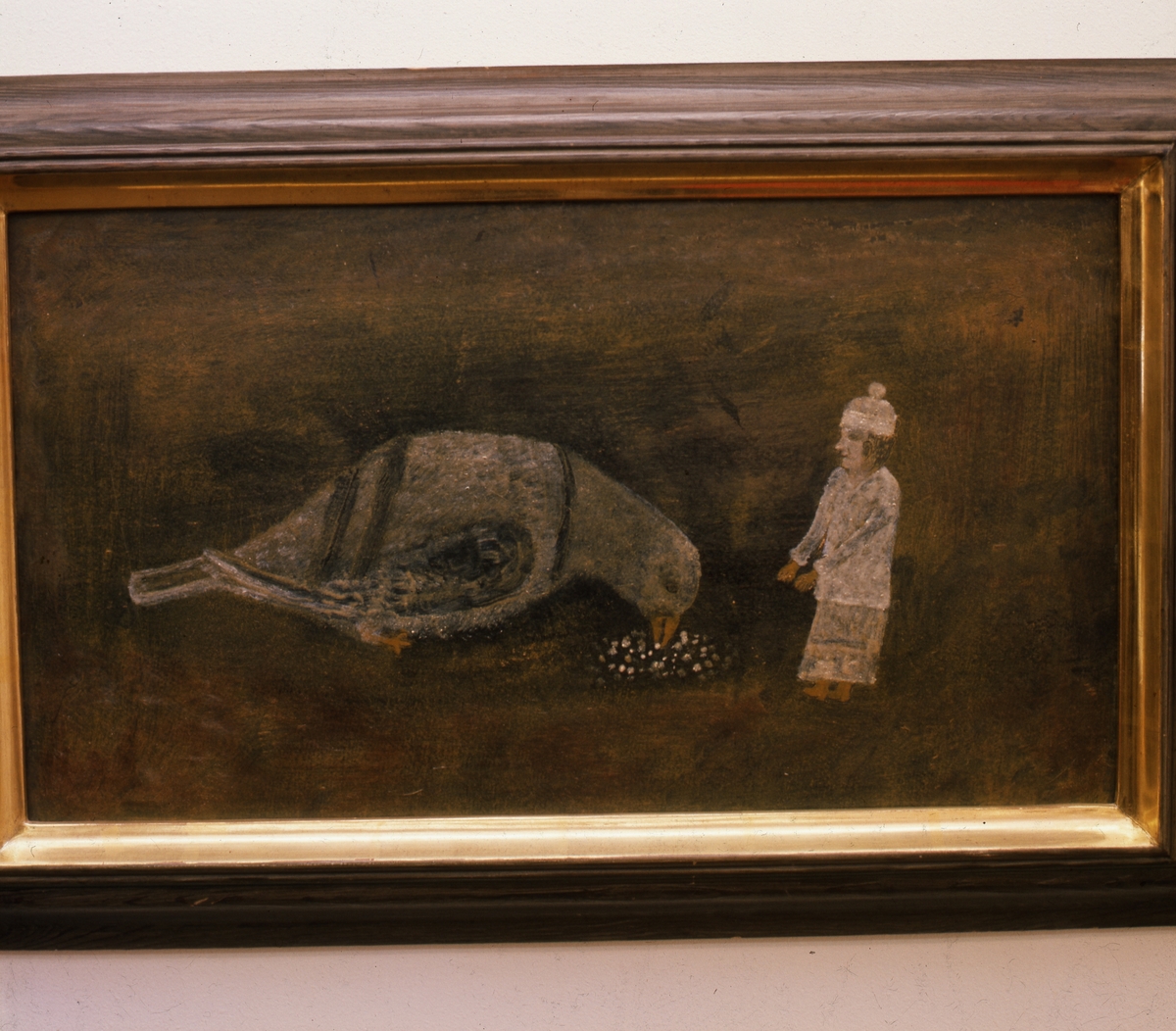 Målning av "Lim-Johan", Johan Erik Olsson född 1865 död 1944. Han var självlärd konstnär och naivist, från Kyan i Hälsingland. Här ett motiv där en kvinna lägger mat på marken framför en stor duva.