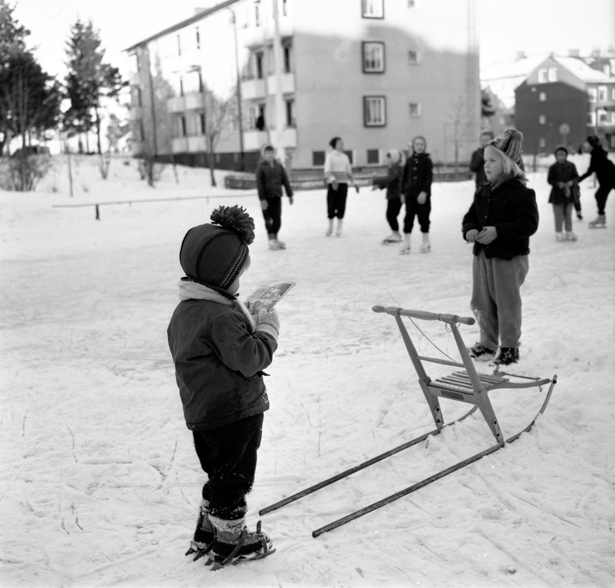 Skridskoåkning på Kristinaplan, Gävle, 1957. Ett barn med sparkkälke.