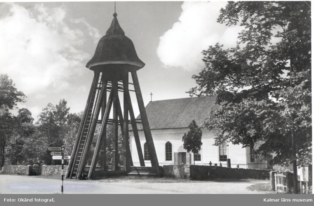 En klockstapel vid en kyrka i nyklassicistisk stil. Karlslunda socken.