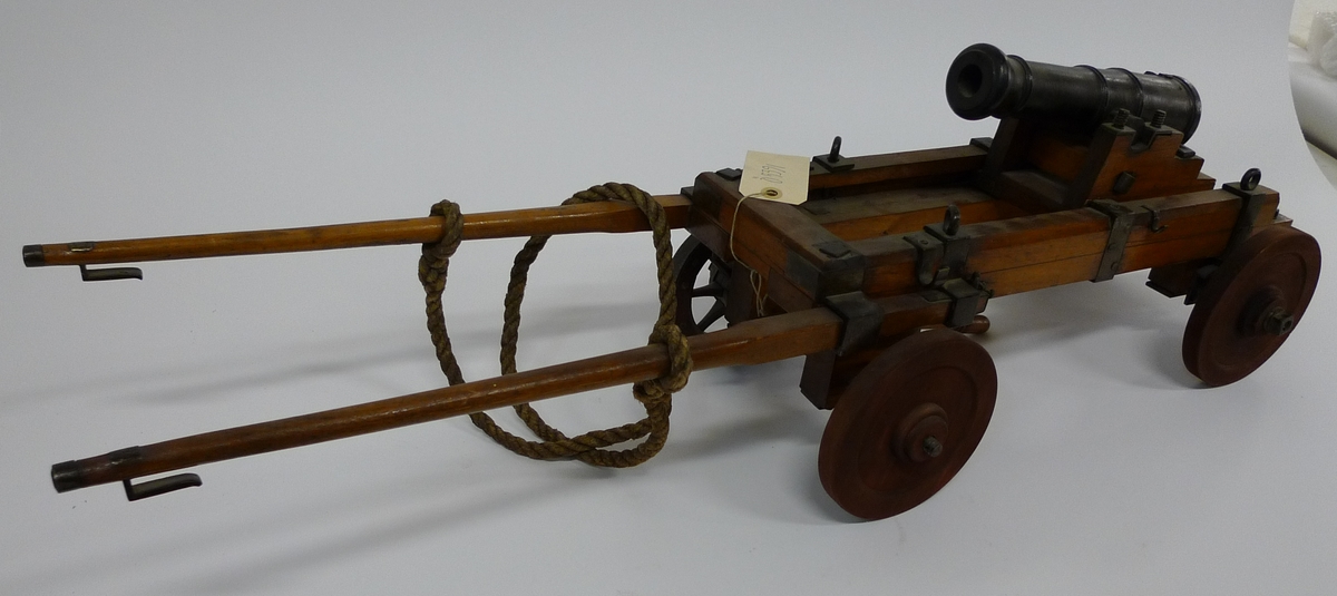 Kanonmodell föreställande 3-pund kanon i vagnkursör.
Landstigningskanon. Kursör av fernissad al på  4 hjul varv 2 st saknas.
Tillhörande brok och skacklar. Beslag av järn. Lavett, fernissad ek,
järnbeslag och riktskruv. Kanon av svartmålat trä. 
Tillh. 2 st  viskare. Skala 1/4.

Kanonens längd:  270 mm
Kursörens ” ”     :  480  mm
Lavetttens  ” ”    : 160 mm
Skacklaernas ”  :535  mm
Kaliber: 19,5  mm
Hjuldiameter: 127 mm