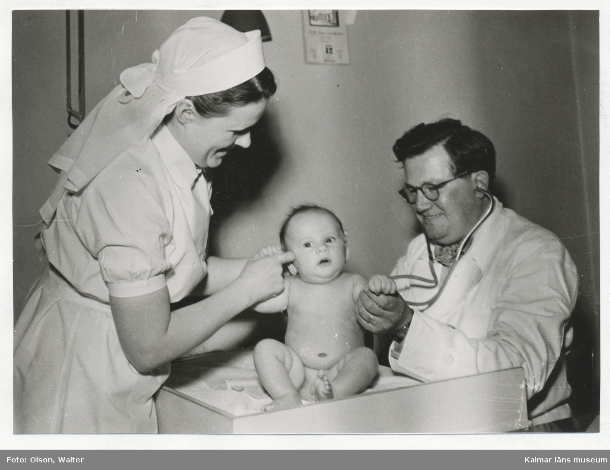 Dr Erik Linde och hans sköterska undersöker en bebis.
