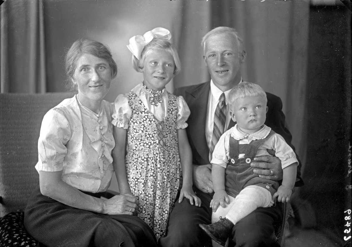 Gruppebilde. Familiegruppe på fire. En kvinne, en mann, en ung pike og en liten gutt. Bestilt av Georg Aarvik. Aarvik. Sønhordland.