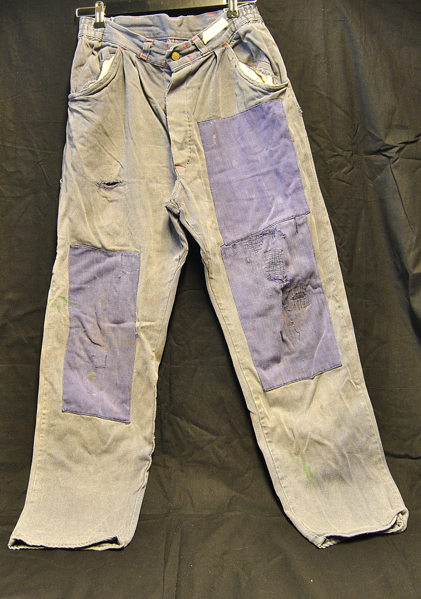 Arbeidsbukse av dongristoff. Bærer preg av bruk. Lappet flere ganger.