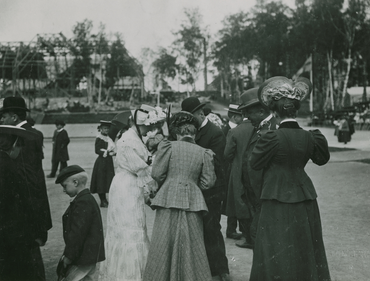 Sällskap i park. Text med blyerts på baksidan: "Idrottsparken. Foto A. Blomberg 1906. NK jubileum 1952."