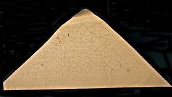 Mönster till knypplad isättning, trekantig, troligen avsedd att som örngottsdekoration. 
Mönstret hör ihop med spetsprov nr. 105968.