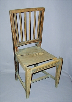 Rödmålad stol med genombruten rygg bestående av 6 räfflade vertikala spjälor. Dekor i form av räfflade spår, även räfflor på ryggstolpar och sarg. Raka 4-sidiga något avsmalnande ben med benkryss. identisk med inv nr 16040, och 22446.